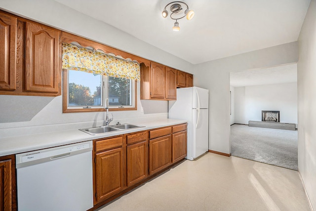 kitchen featuring light carpet, sink, and white appliances