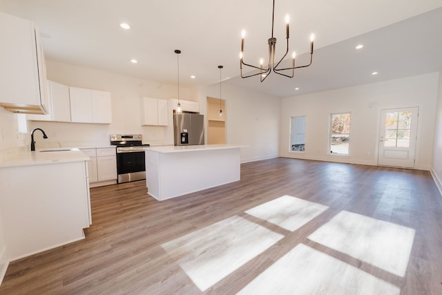 kitchen with appliances with stainless steel finishes, a center island, light hardwood / wood-style flooring, and white cabinetry