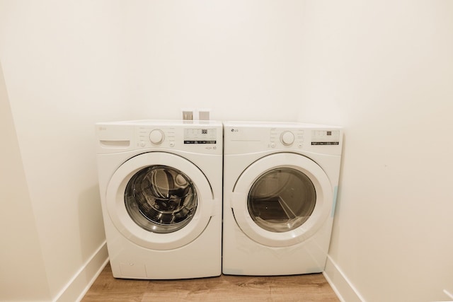 laundry room featuring separate washer and dryer and light wood-type flooring