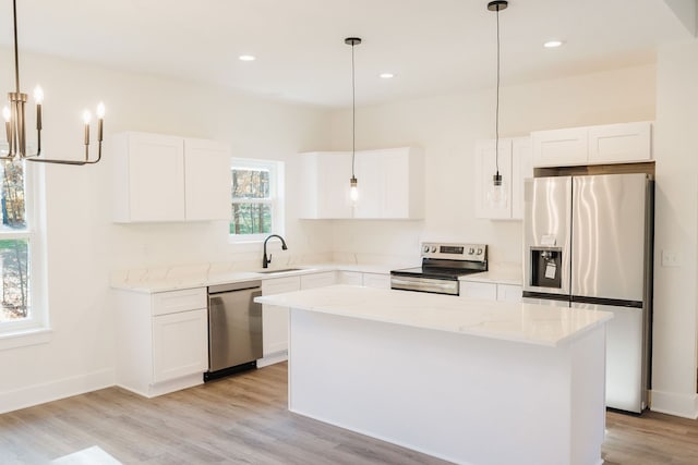 kitchen featuring a kitchen island, sink, appliances with stainless steel finishes, and light hardwood / wood-style flooring