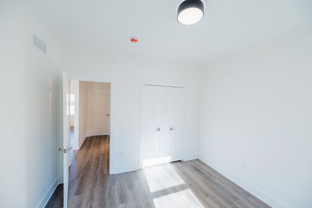 unfurnished bedroom featuring light hardwood / wood-style flooring and a closet