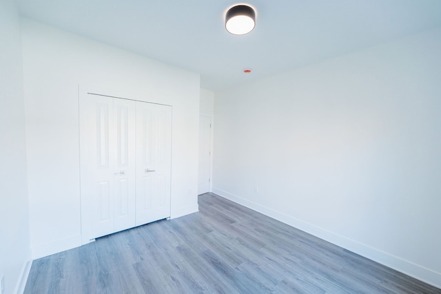 unfurnished bedroom featuring a closet and hardwood / wood-style flooring