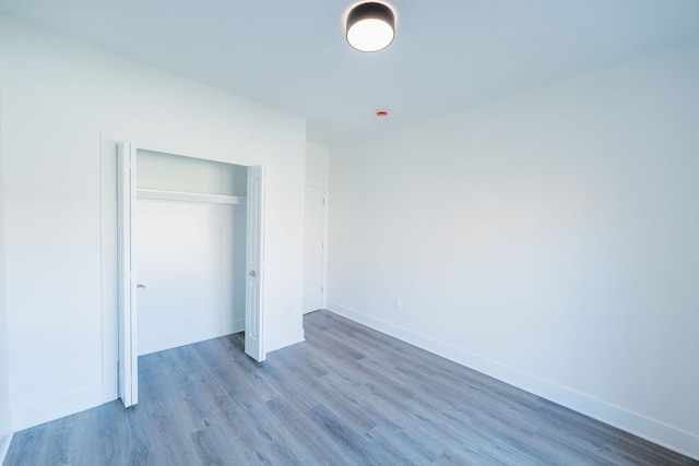 unfurnished bedroom with a closet and hardwood / wood-style floors