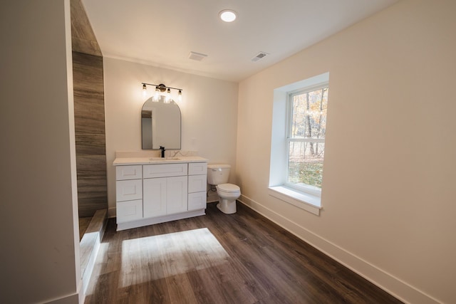 bathroom with hardwood / wood-style floors, vanity, and toilet