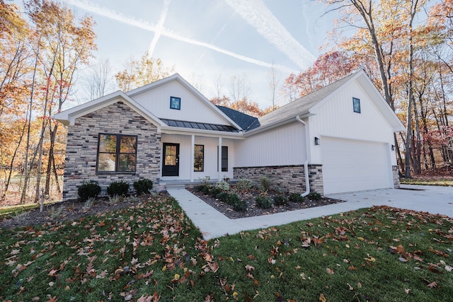 modern farmhouse style home featuring covered porch, a garage, and a front yard