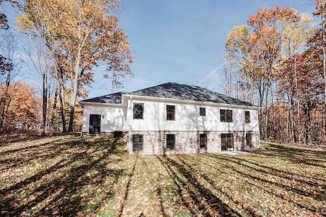 rear view of property with a yard and central AC