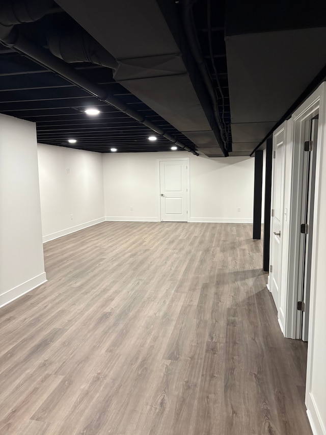 basement with light hardwood / wood-style flooring