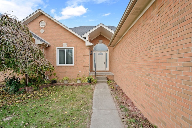 doorway to property with a lawn