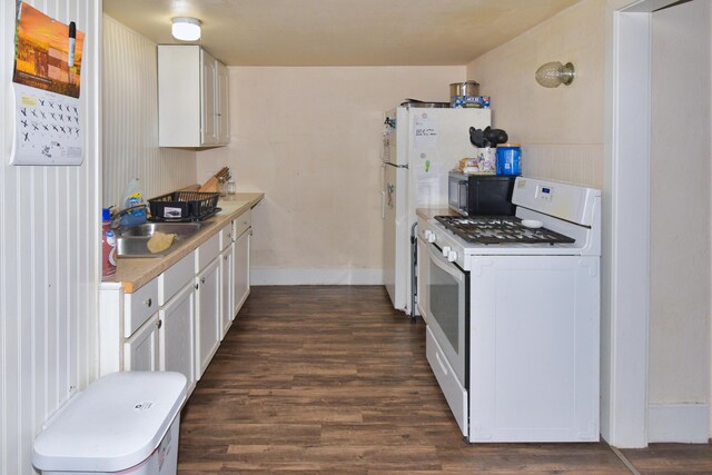 221 N 6th St, Niles, MI 49120 - kitchen featuring white gas range oven, dark wood-type flooring, a sink, light countertops, and white cabinets