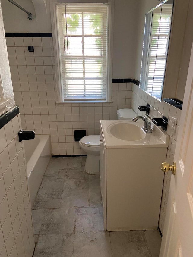 bathroom featuring vanity, toilet, and tile walls