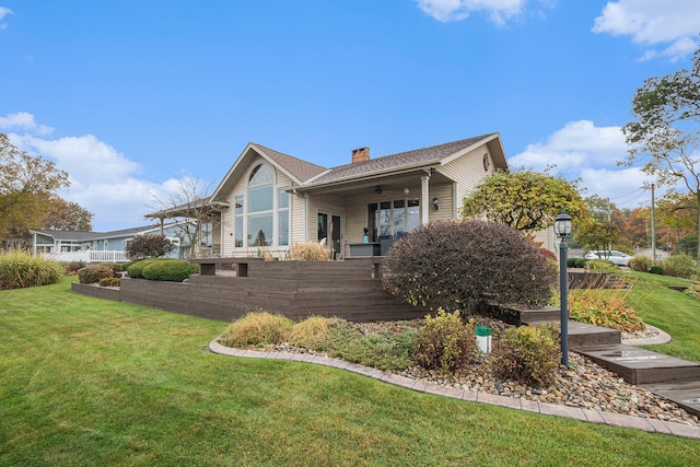 rear view of house with a yard and ceiling fan