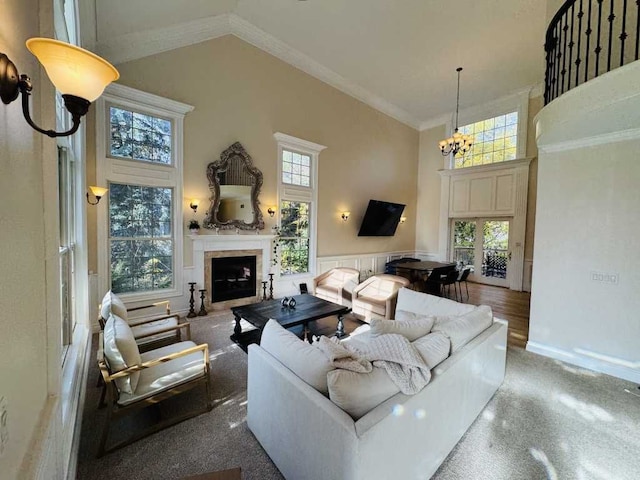 living room featuring carpet flooring, crown molding, high vaulted ceiling, and a notable chandelier