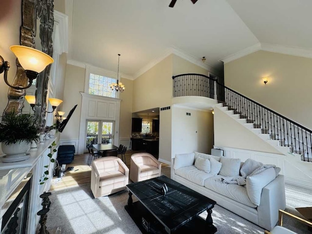 carpeted living room featuring an inviting chandelier, high vaulted ceiling, and ornamental molding