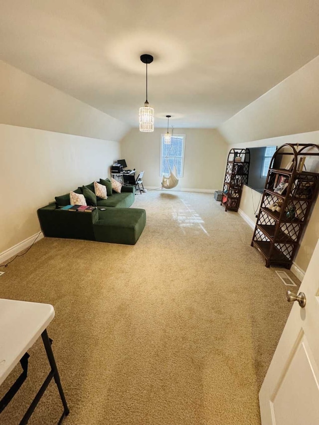 interior space featuring carpet floors, lofted ceiling, and a notable chandelier