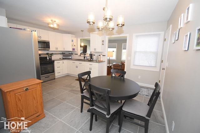 tiled dining space with a chandelier and sink