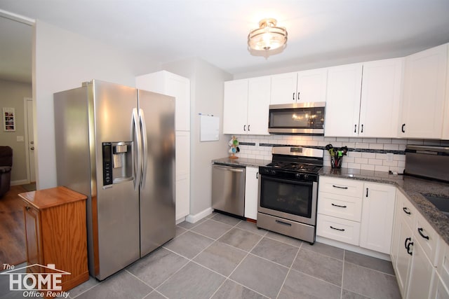 kitchen featuring white cabinets, decorative backsplash, and stainless steel appliances