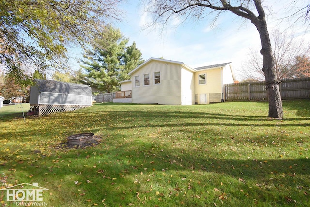 view of yard with a fire pit and a storage shed