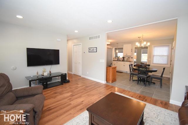 living room featuring a chandelier, light hardwood / wood-style floors, and sink