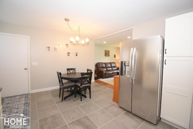 dining space with light tile patterned flooring and a notable chandelier