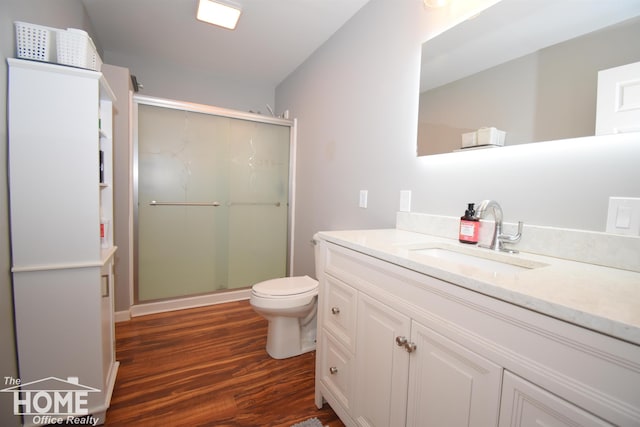 bathroom with vanity, wood-type flooring, a shower with shower door, and toilet