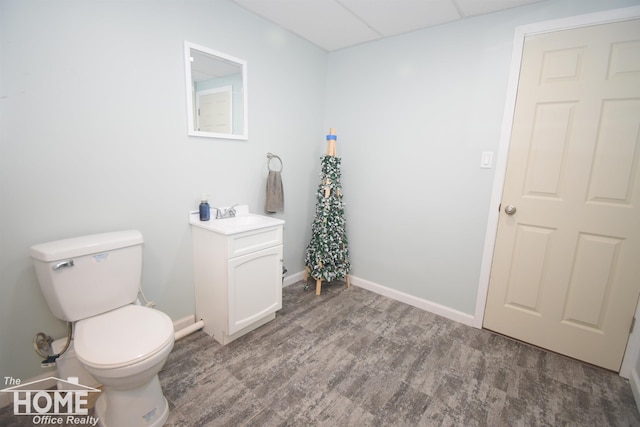 bathroom with vanity, hardwood / wood-style flooring, toilet, and a drop ceiling