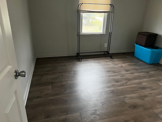 unfurnished room with dark wood-type flooring