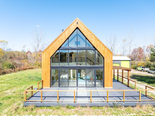 rear view of house featuring a lawn and a deck