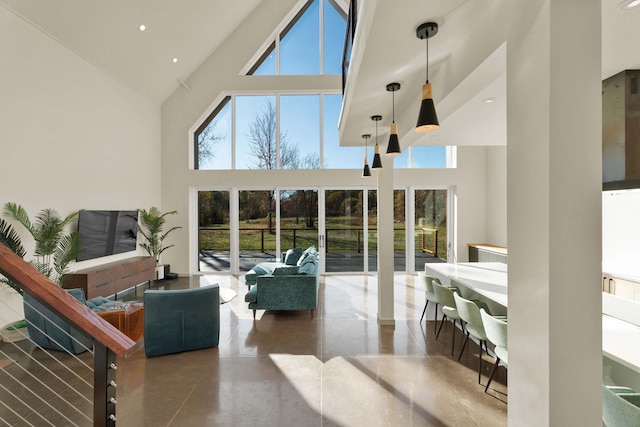 living room featuring concrete flooring, high vaulted ceiling, and a wealth of natural light