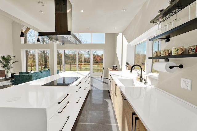 interior space featuring white cabinetry, black electric stovetop, and a high ceiling