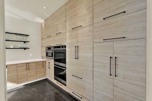 kitchen featuring double oven and light brown cabinetry