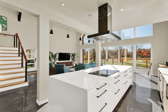 kitchen featuring island exhaust hood, black electric stovetop, a high ceiling, a center island, and white cabinetry