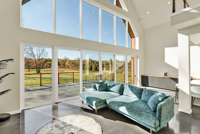 living room with high vaulted ceiling and a healthy amount of sunlight