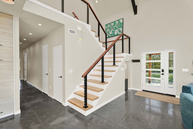 stairway with a high ceiling and concrete floors