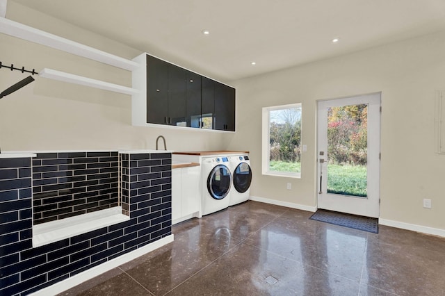 washroom with cabinets and washing machine and clothes dryer