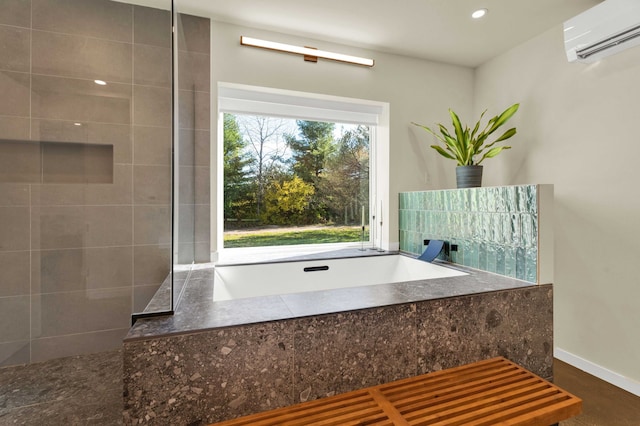 bathroom with a tub to relax in and a wall mounted AC