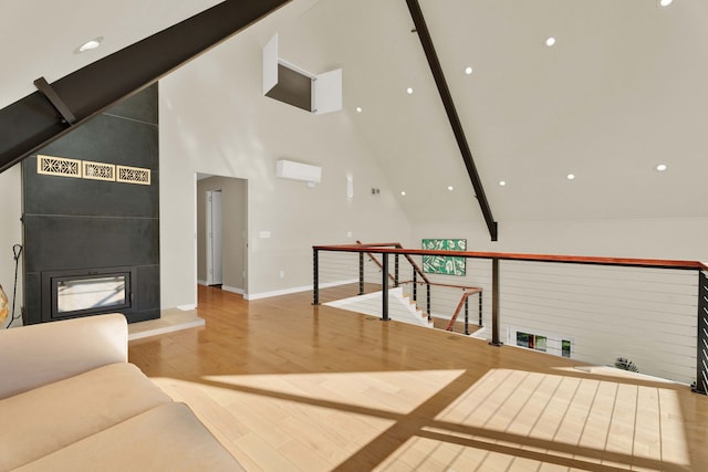 living room featuring a fireplace, beamed ceiling, high vaulted ceiling, and light wood-type flooring