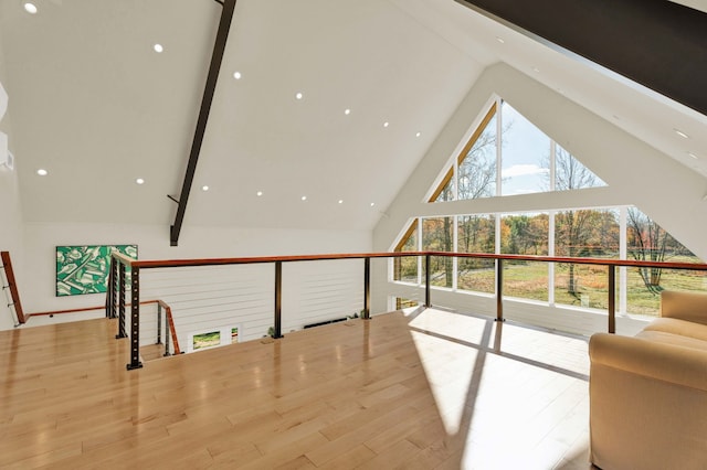 living room with beam ceiling, light wood-type flooring, and high vaulted ceiling