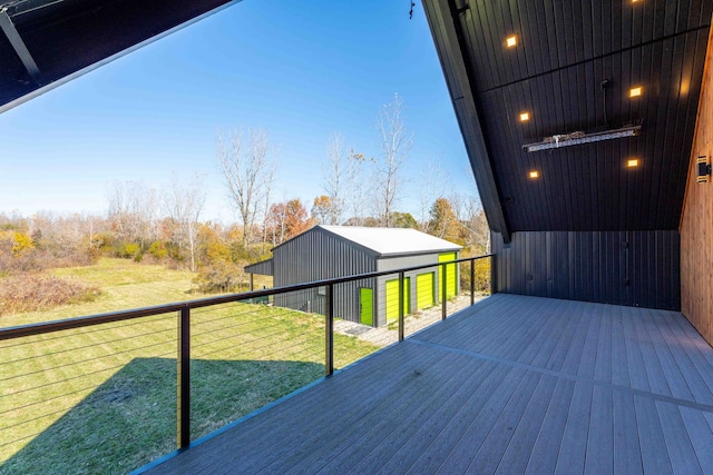 wooden terrace featuring a lawn and an outdoor structure