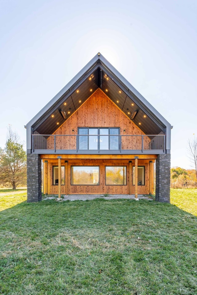 back of property with a lawn and a balcony