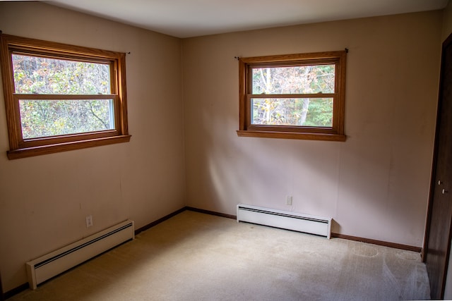 carpeted spare room featuring baseboard heating