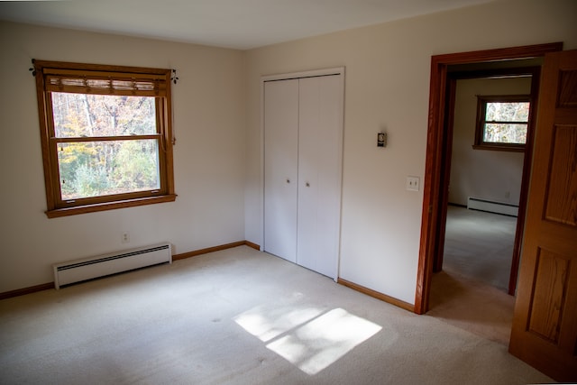 unfurnished bedroom with multiple windows, a closet, and a baseboard radiator