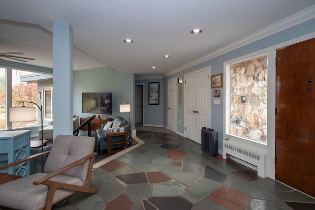 foyer entrance featuring radiator, ceiling fan, and crown molding