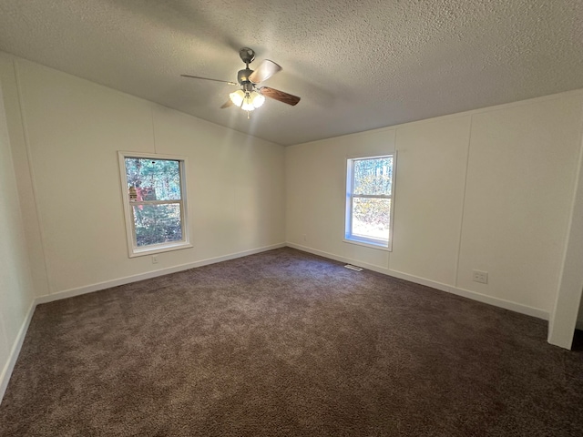 carpeted spare room featuring a textured ceiling, vaulted ceiling, and ceiling fan