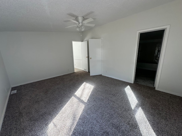 unfurnished bedroom with dark carpet, a textured ceiling, ensuite bath, and ceiling fan