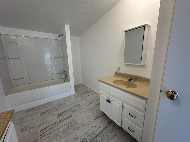 bathroom with a textured ceiling, vanity, and  shower combination