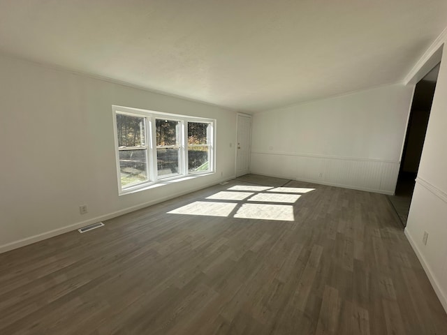 empty room featuring dark hardwood / wood-style floors and ornamental molding