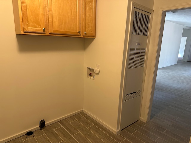 clothes washing area featuring dark hardwood / wood-style flooring, cabinets, and washer hookup