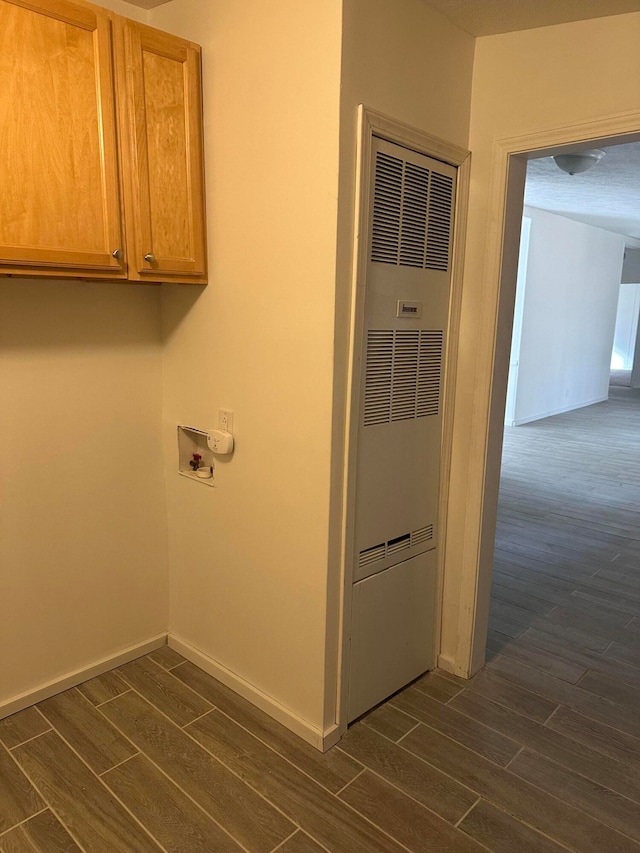 laundry area featuring washer hookup, cabinets, and dark wood-type flooring