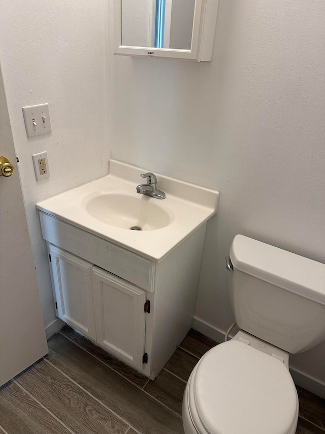 bathroom featuring vanity, wood-type flooring, and toilet