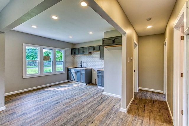 kitchen featuring wood-type flooring, sink, and tasteful backsplash